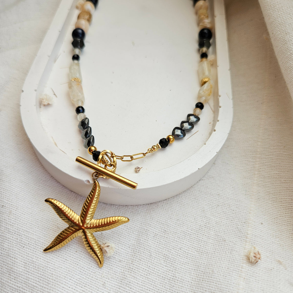 Black and yellow mixed stone necklace with a starfish pendant, citrine, landscape jasper, black tourmaline, Blue Goldstone, hematite and stainless steel details.