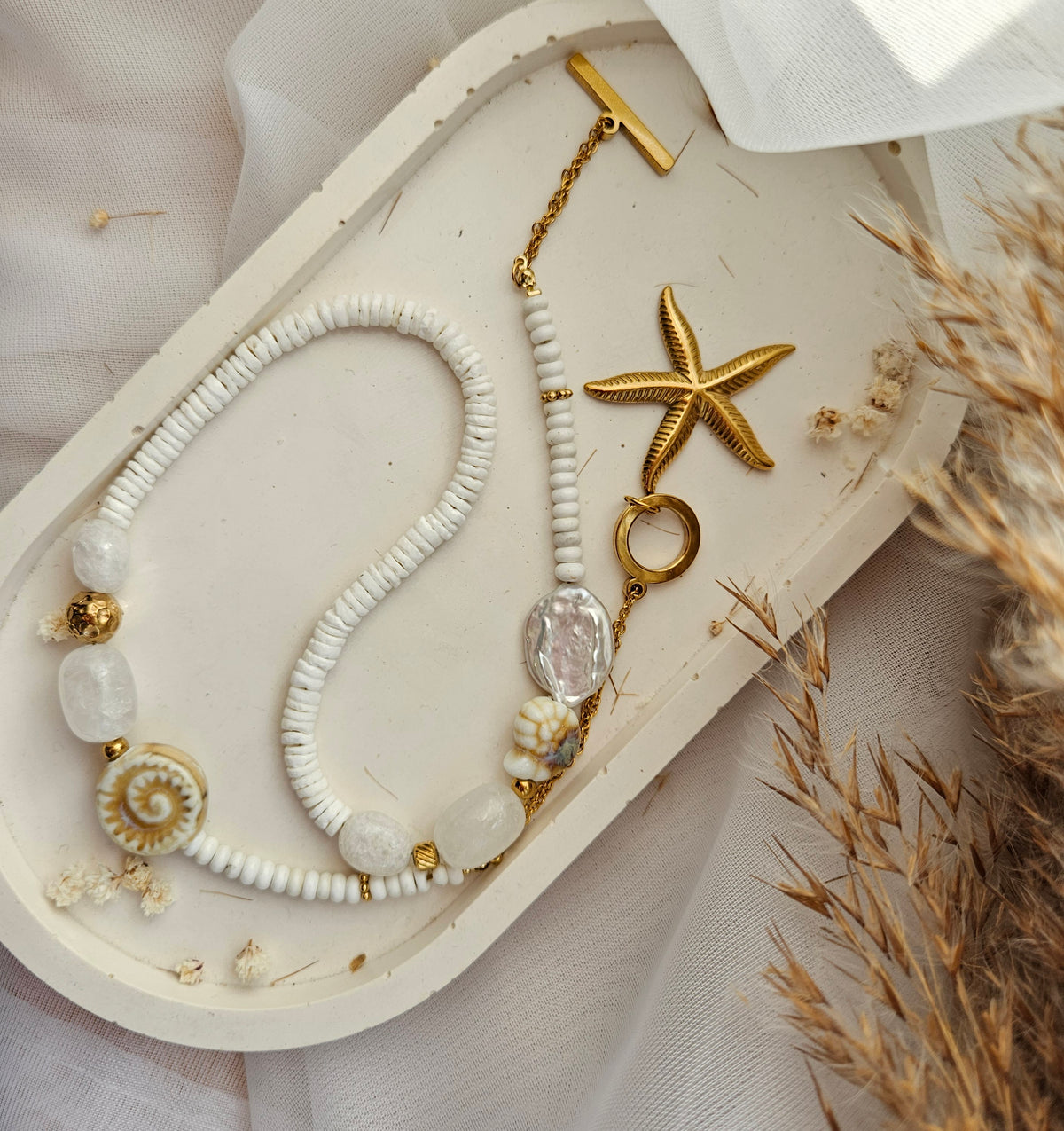 White beaded necklace with a starfish pendant, white howlite, shell beads, white jade and silver-tone stainless steel details.