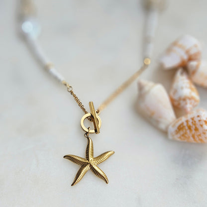 White beaded necklace with a starfish pendant, white howlite, shell beads, white jade and silver-tone stainless steel details.